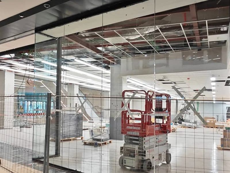 Cerramiento de vidrio sobre estructura de acero en acceso de nave