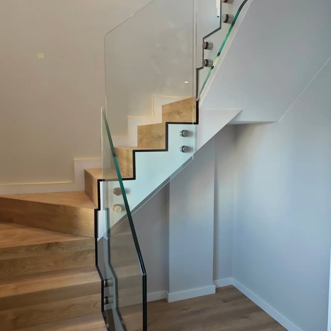 Escalera con barandilla de cristal terminada en una vivienda de A Coruña